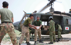 被災地でヘリコプターから物資を降ろす自衛隊員とパキスタン軍兵士