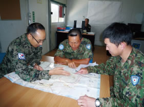 韓国軍兵士（左）と調整を行う陸自隊員