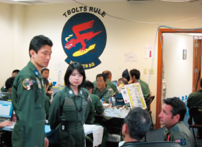 ブリーフィングルームで豪空軍パイロットと訓練の調整を行う筆者（左）