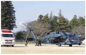 急患輸送を実施中の空自隊員および消防隊員の画像