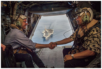 南シナ海上、オスプレイ機上で握手する米比国防相（背後は空母ステニス）（16（平成28）年4月15日）【米海兵隊提供】の画像