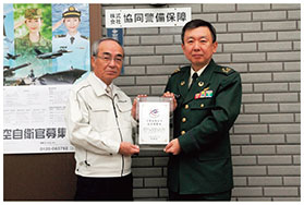 鳥取地方協力本部長から表示証の交付を受ける筆者（左）の画像