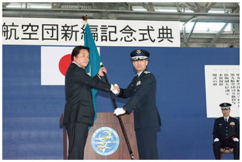 空自那覇基地において若宮防衛副大臣から隊旗を授与される第9航空団司令の画像