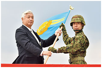 中谷防衛大臣から陸自与那国沿岸監視隊の隊旗を授与される西部方面総監の画像