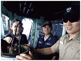 操艦訓練に向けて、コンパスの使用法を確認する筆者（中央）の画像