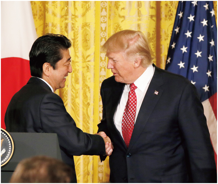 日米共同記者会見においてトランプ米大統領と握手を交わす安倍内閣総理大臣（17（平成29）年2月）【内閣広報室提供】