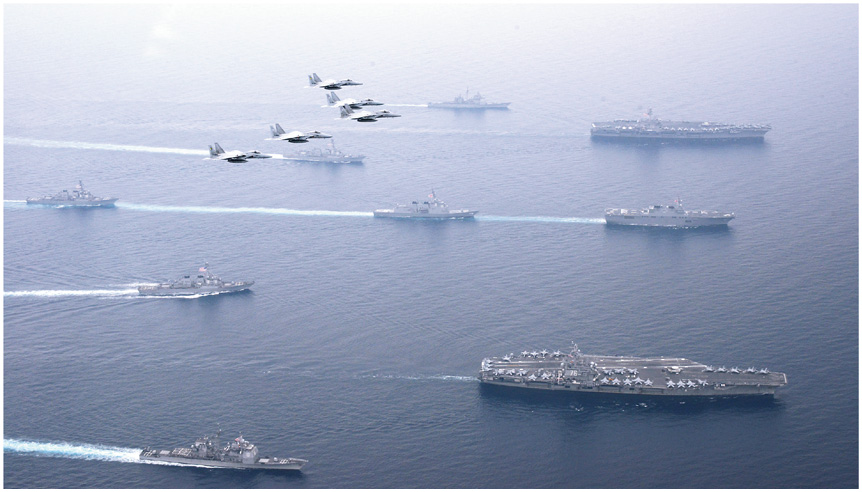 米海軍空母「ロナルド・レーガン」（手前）や「カール・ヴィンソン」（奥）などと航行する海自護衛艦「ひゅうが」及び「あしがら」（中央2隻）と空自F-15戦闘機（17（平成29）年6月）