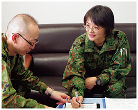 衛生隊長の業務指導を受ける筆者（右）