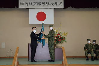 岩田防衛大臣政務官から隊旗を授与される輸送航空隊長（20（令和2）年４月）